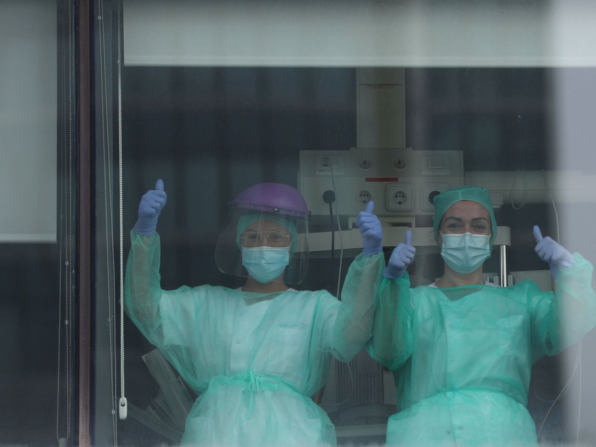 Foto: Dos enfermeras saludan desde las ventanas de La Paz, en Madrid. (Reuters)