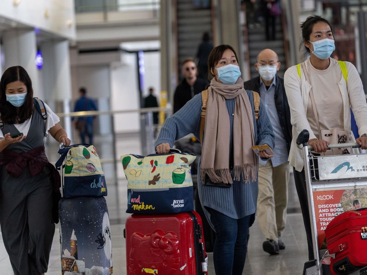 Foto: Un grupo de pasajeros chinos llegan al aeropuerto de Hong Kong. (EFE)