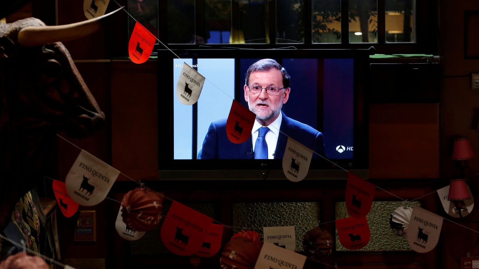 Foto: El líder del PP, Mariano Rajoy, en la pantalla de televisión de un restaurante durante el debate. (Reuters)