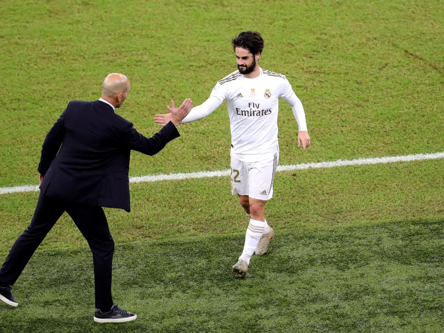 Zidane choca la mano de Isco tras ser sustituido. (Efe)