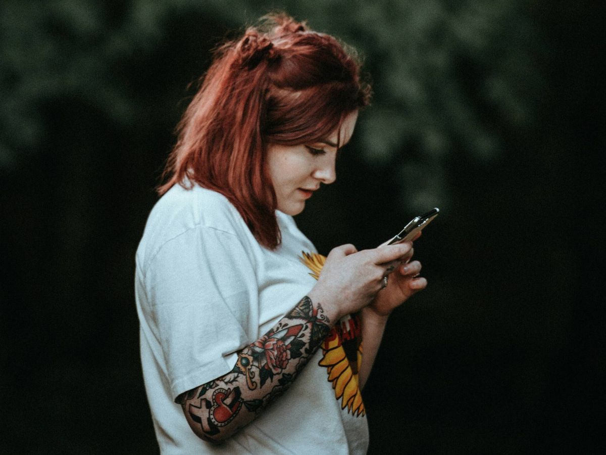 Foto: Una joven mira su móvil. (Unsplash/Annie Spratt)