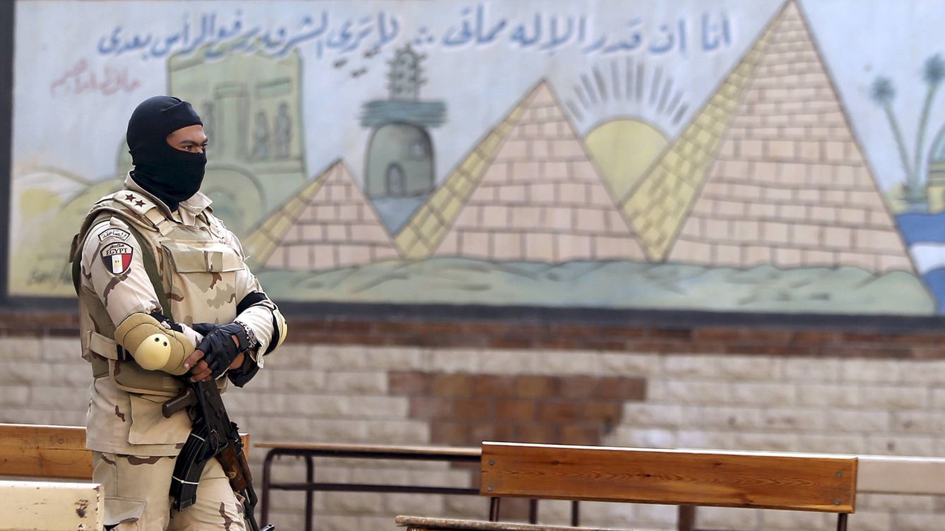 Foto: Un miembro de las fuerzas especiales egipcias monta guardia frente a un mural escolar de las pirámides y el Nilo, en noviembre de 2015. (Reuters)