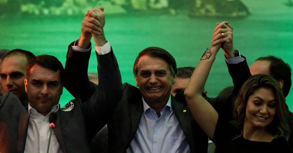 Foto: Bolsonaro levanta el brazo de la victoria junto a su esposa.(EFE)