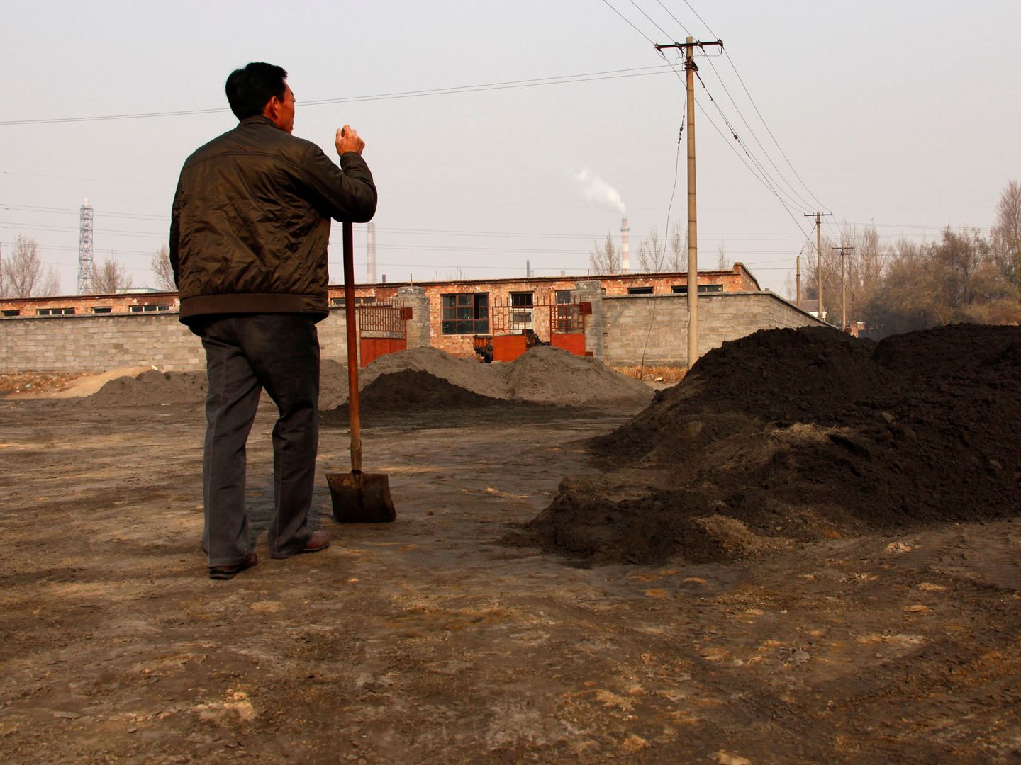 Un ciudadano de Baotou mira una de las plantas de 'tierras raras' de la región. (Reuters)