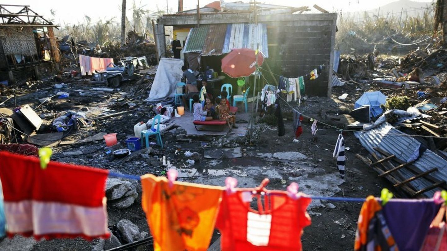 Supervivientes pasan el tiempo a las puertas de sus casas destrozadas en Tacloban (Reuters)