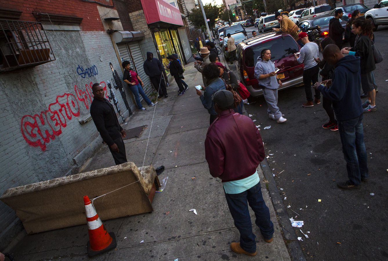 Vecinos del Bronx observan un grafiti del artista británico Banksy, en Nueva York, el 21 de octubre de 2013. (Reuters)
