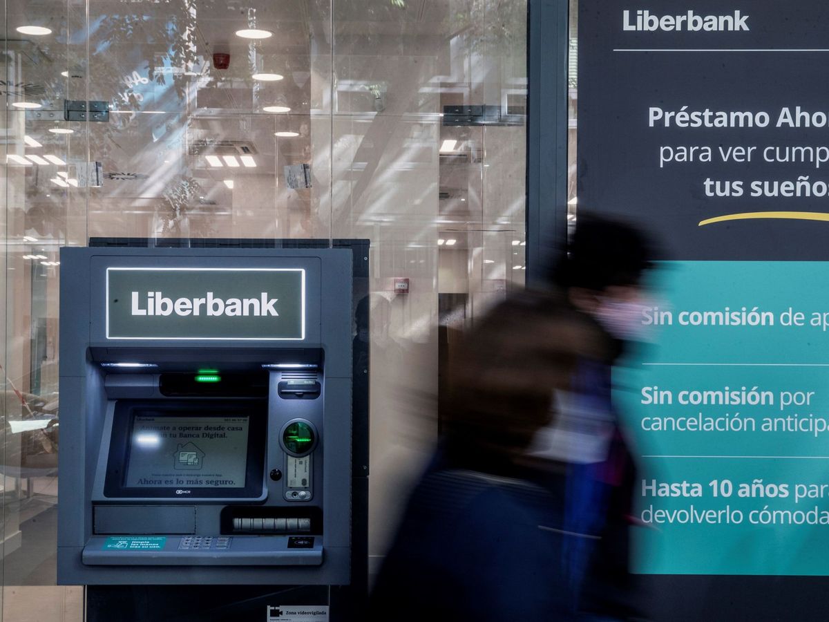 Foto: Dos personas pasan ante una oficina de Liberbank en Madrid. (EFE)