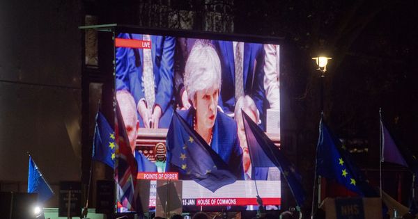 Foto: Decenas de personas agitan banderas de la UE mientras miran la intervención de Theresa May en la votación del acuerdo del Brexit, este 15 de enero en Londres. (EFE)