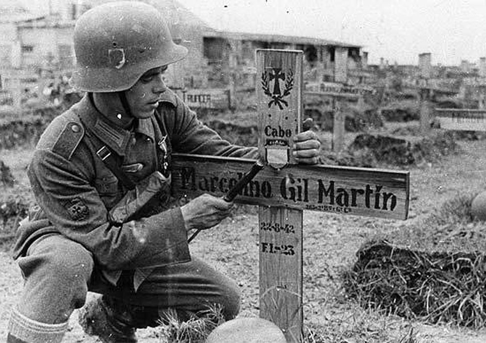 Foto: Un soldado español, con la ayuda de su machete, acaba de incrustar en la cruz de un compañero caído el símbolo de la unidad.