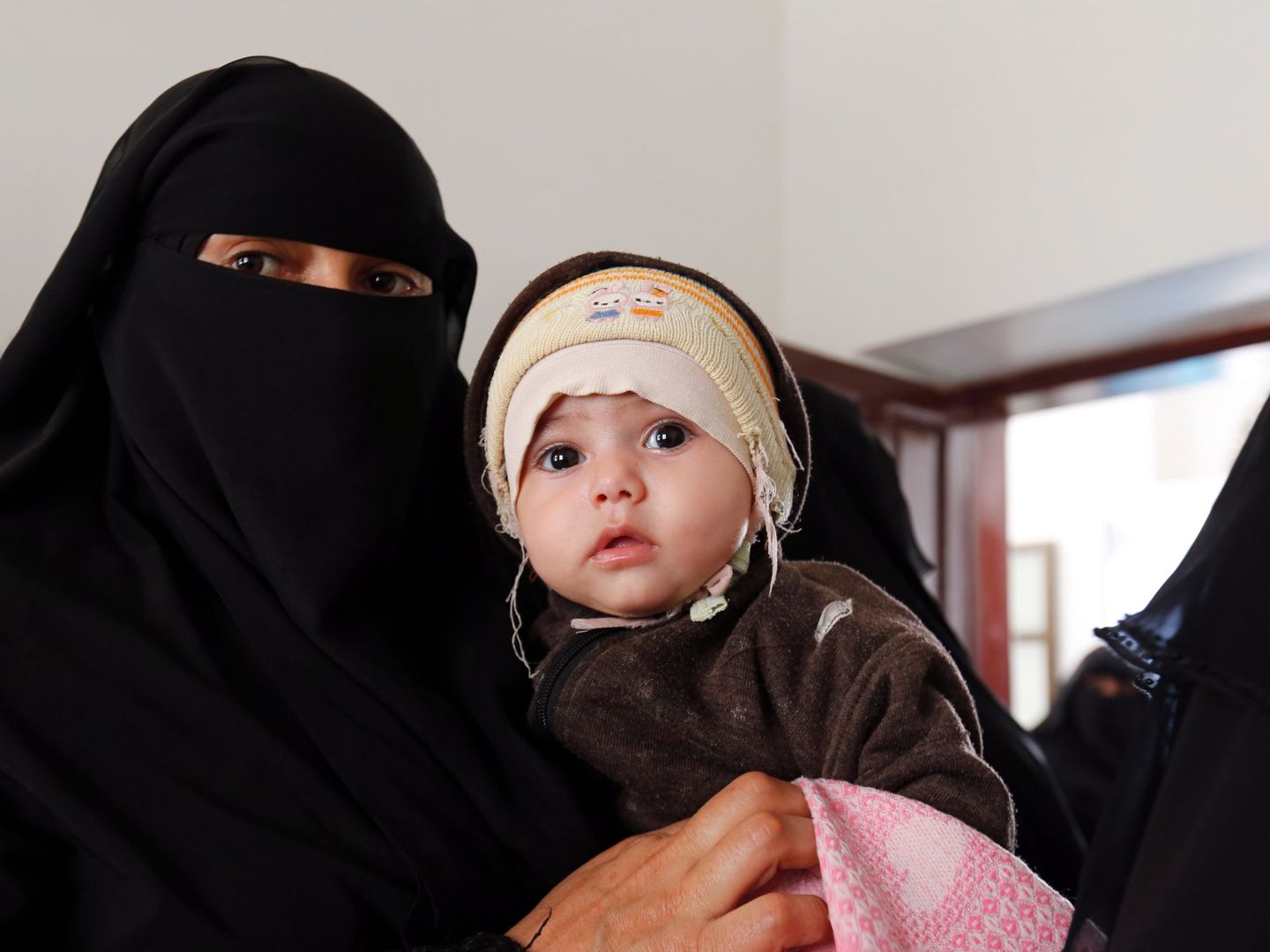 Una mujer espera a que su hijo reciba la vacuna contra la polio en un centro de salud, en Saná, Yemen (Yahya Arhab / EFE)