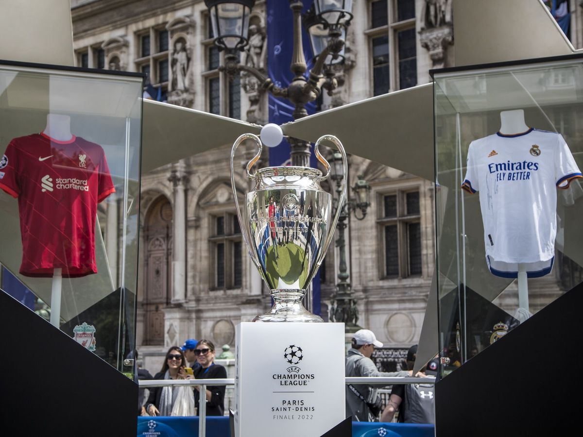 Foto: El trofeo de la Liga de Campeones expuesto entre las camisetas del Liverpool y del Madrid en una zona de aficionados en Paris. (EFE)