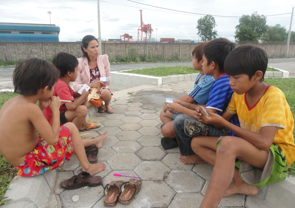 Foto: Una trabajadora social de Protect con un grupo de niños en Sihanoukville (Camboya). (Action pour les Enfants)