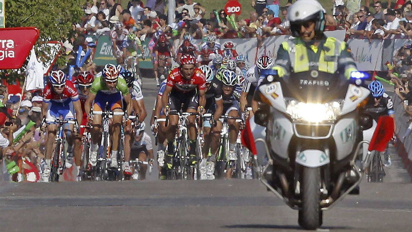 Una moto de la Guardia Civil ante un grupo ciclista en la Vuelta (EFE/José Manuel Vidal).