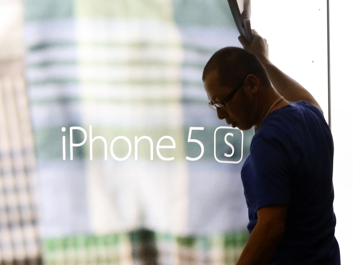 Foto: Empleado de Apple retira un cartel del iPhone 5S (REUTERS/Yuya Shino)