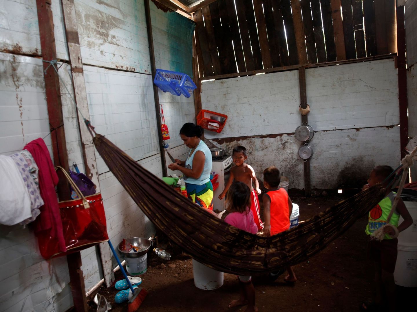 Una mujer, acompañada por sus hijos, prepara alimentos en Ciudad de Panamá (Panamá). (EFE)