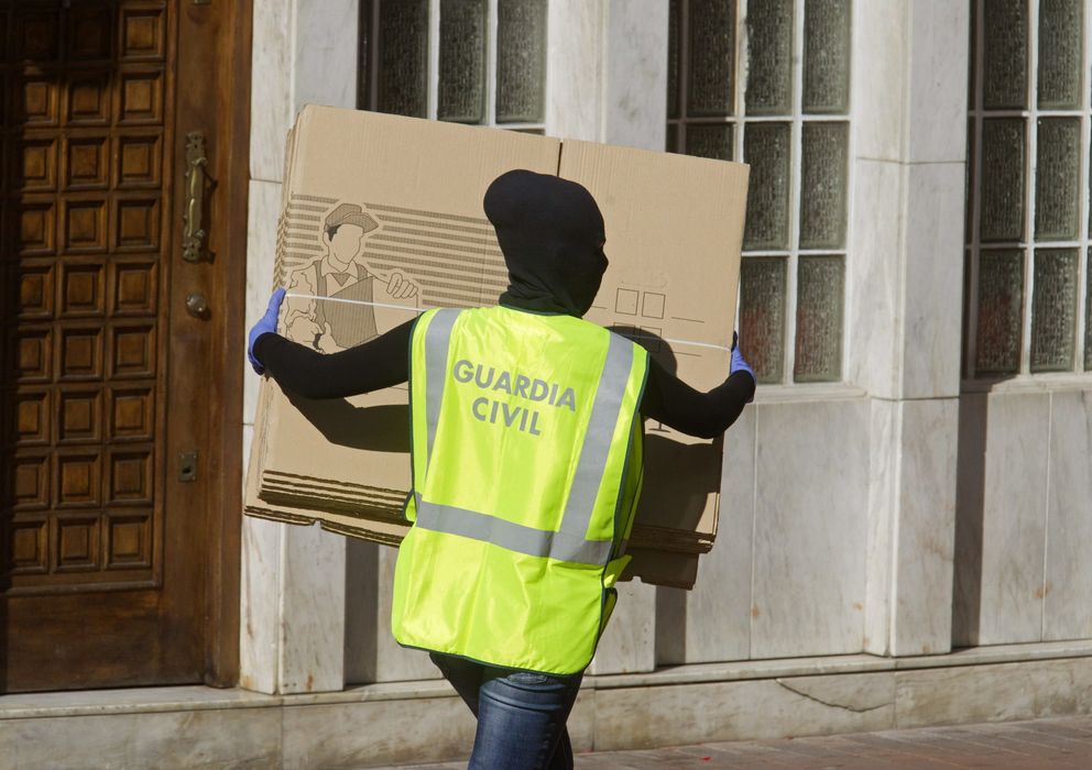 Foto: Un agente de la Guardia Civil transporta unas cajas con documentos de colaboradores de ETA (Efe)