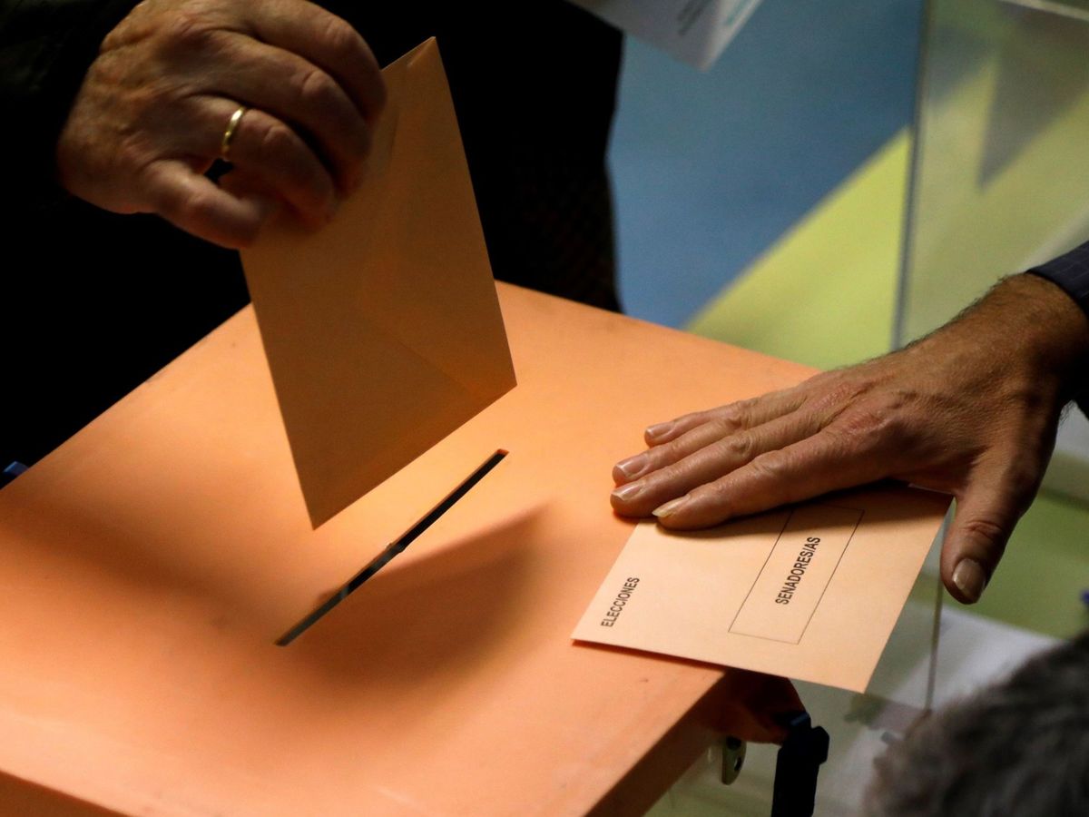 Foto: Un elector deposita su voto en un colegio electoral de Madrid (EFE)