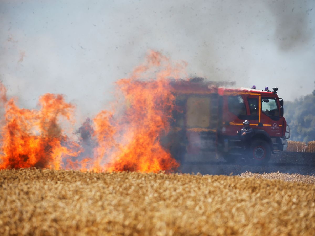 Foto: Bomberos franceses extinguen el fuego de un campo de trigo en Ramillies, Francia. (Reuters/Pascal Rossignol)