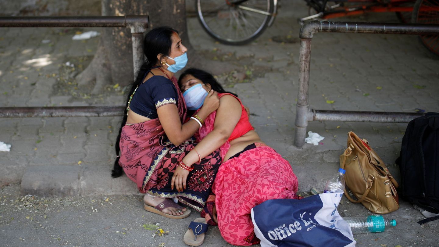 Unas mujeres lloran la muerte de un ser querido por coronavirus a las afueras de un crematorio en Nueva Delhi. (Reuters)