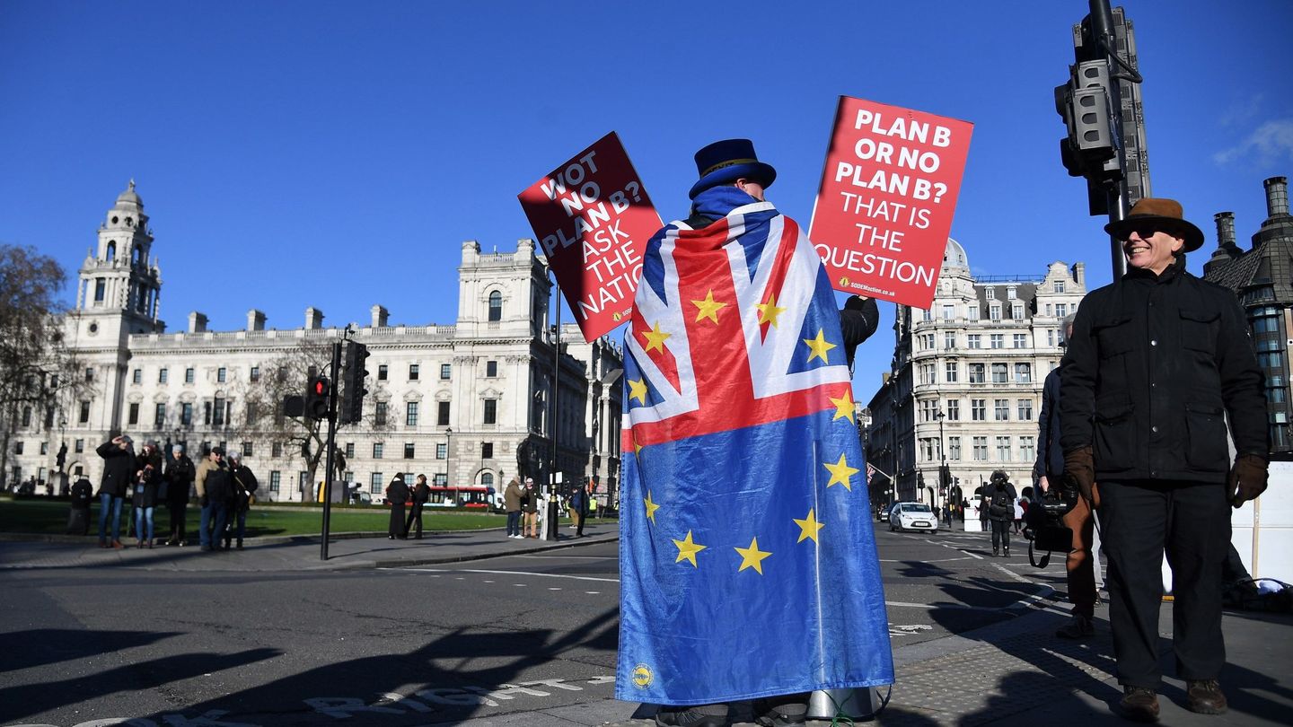 Un activista en contra del Brexit sostiene pancartas ante el edificio del Parlamento británico, en Londres. (EFE)