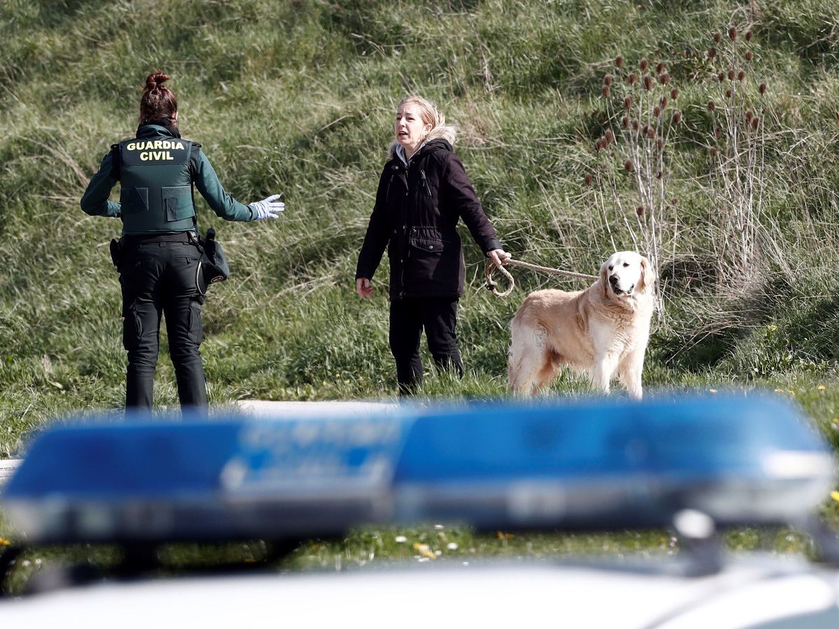 Foto: Un efectivo de la Guardia Civil conversa con una persona que acompañada de su perro en Pamplona. (EFE)