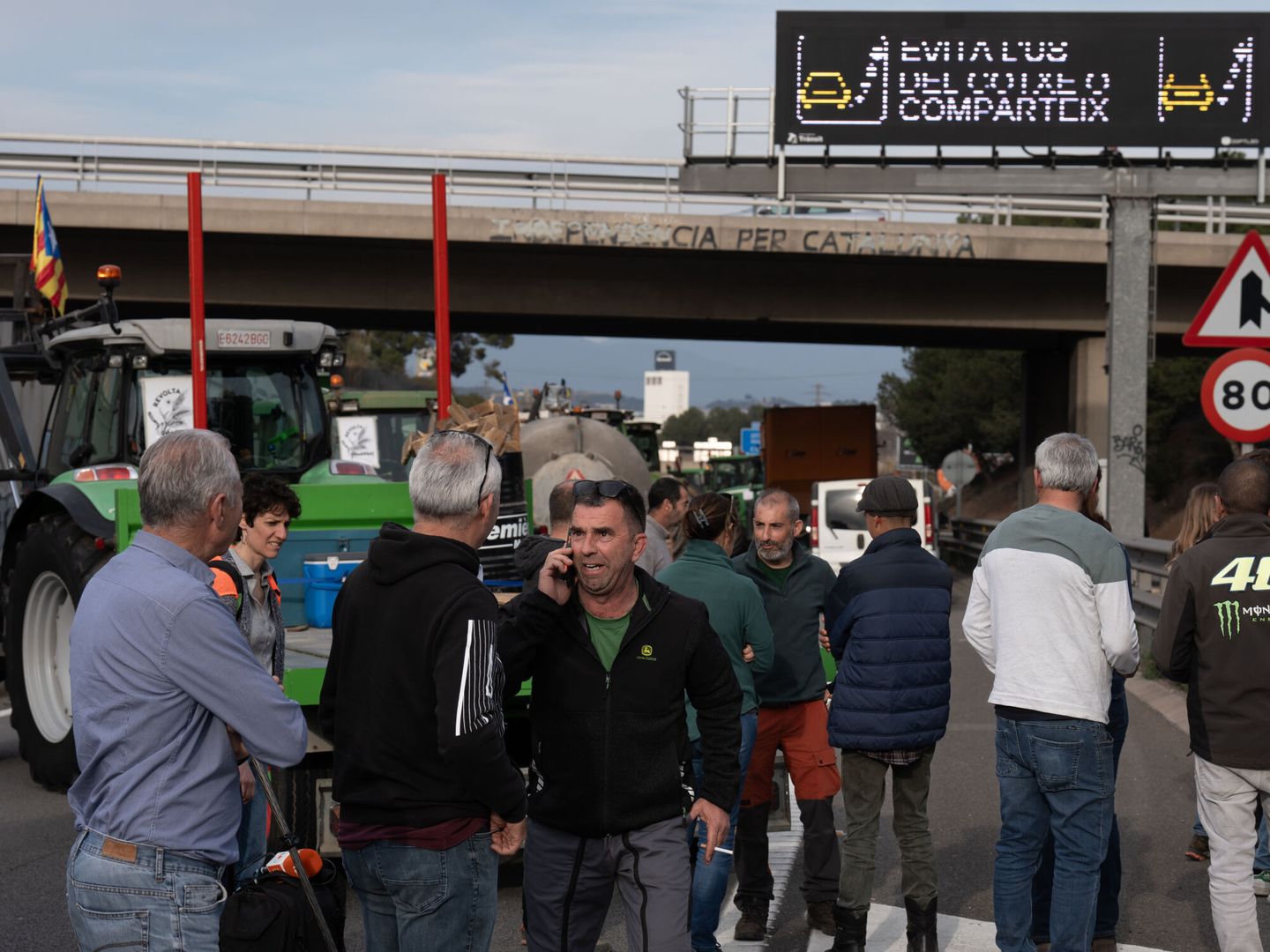 Varios agricultores, a pie de autovía, en una de las columnas de Cataluña. (EP)