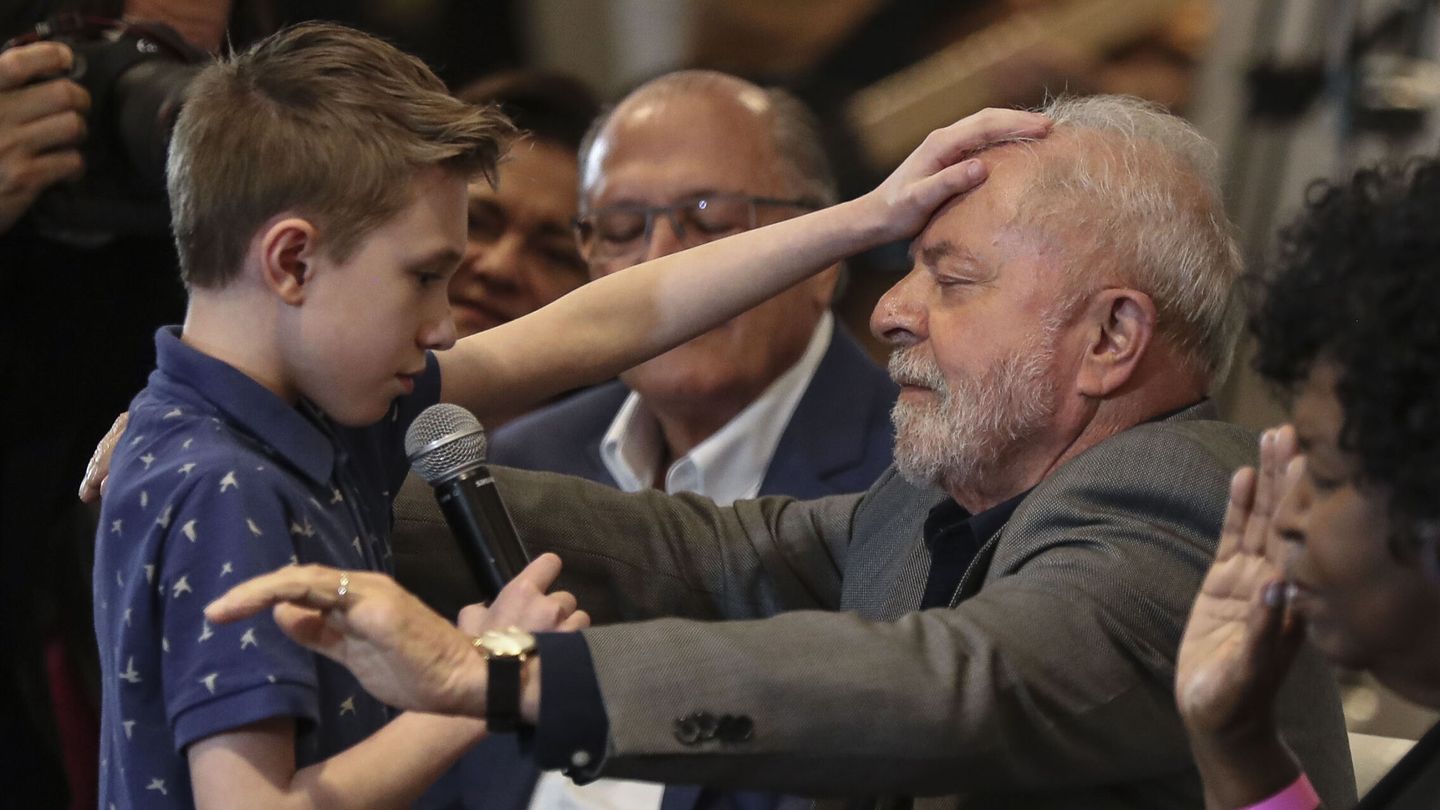 Luiz Inácio Lula da Silva recibe una oración de David Mikami, de nueve años de edad, durante un acto de campaña. (EFE/Sebastiao Moreira)