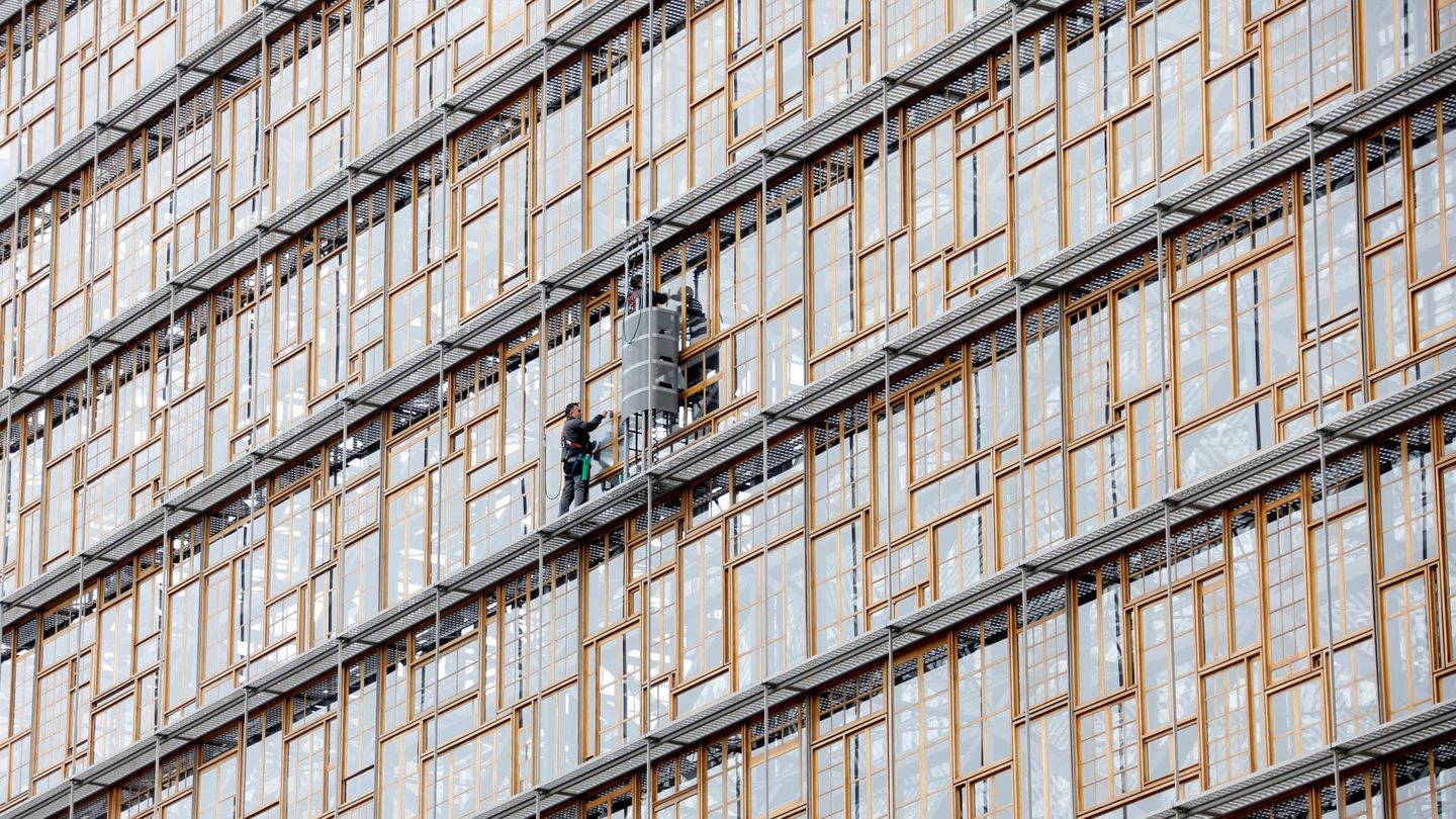 Dos trabajadores limpian los cristales del Consejo Europeo. (Reuters)