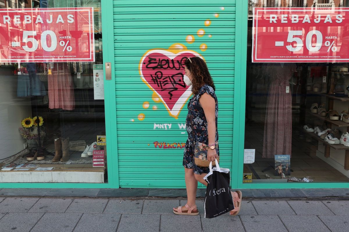 Foto: Una mujer pasa ante una tienda en rebajas. (EFE)