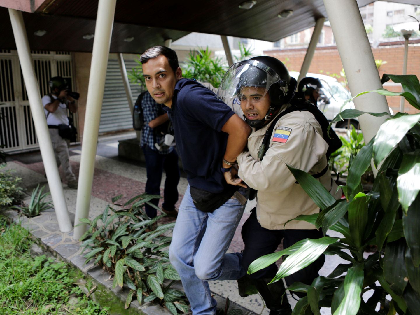 Un policía antidisturbios detiene a un manifestante. (Reuters)