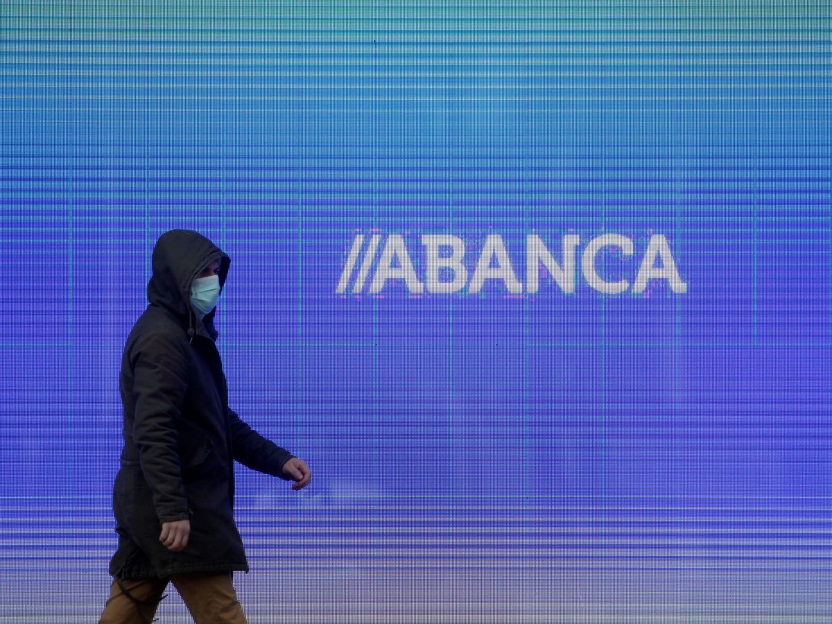 Foto: Un hombre camina frente a la sede central de Abanca en A Coruña. (EFE) 