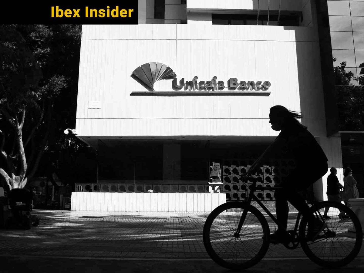 Foto: Una mujer pasea en bicicleta frente a la sede de Unicaja en Málaga. (Europa Press/Alex Zea)