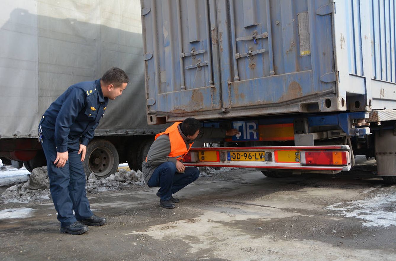 Dos trabajadores de la aduana de Khorgos examinan el vehículo tras la travesía. (Fuente: IRU)