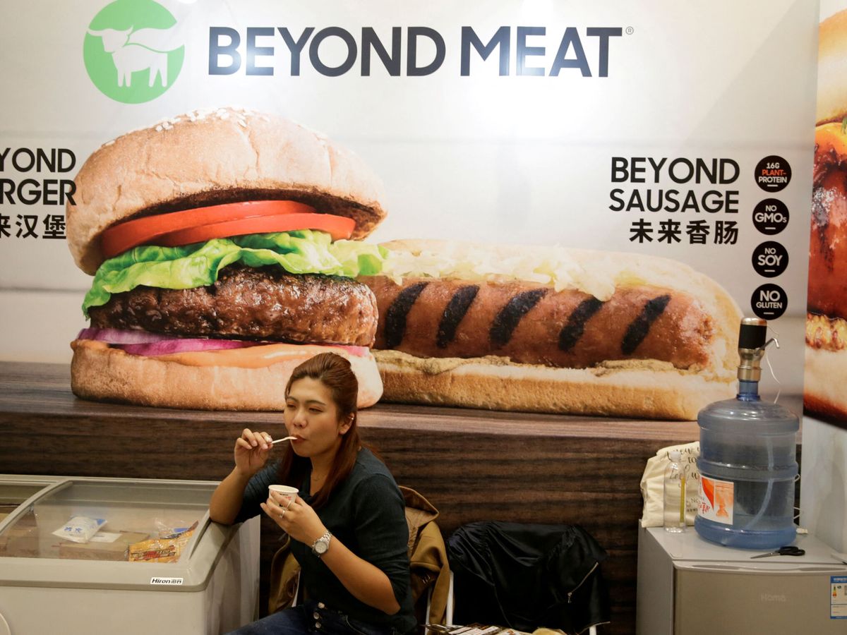 Foto: Una mujer con un cartel de Beyond Meat detrás. (Reuters/Jason Lee)