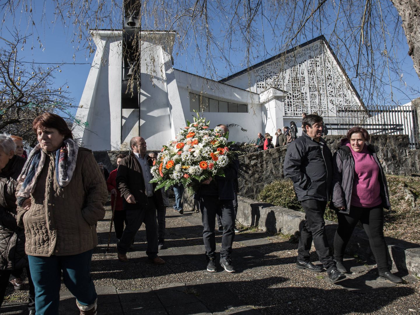 Asistentes a la misa en recuerdo de la tragedia llevan una corona al monumento a las víctimas. (D. B.)
