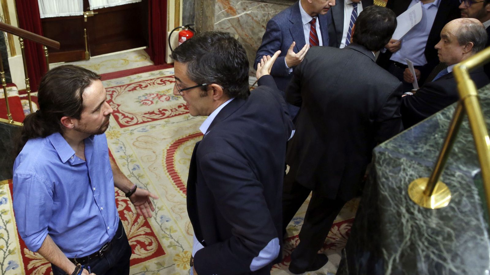 Foto: El secretario general de Podemos, Pablo Iglesias, y el diputado socialista Eduardo Madina conversan tras un pleno del Congreso. (Efe)