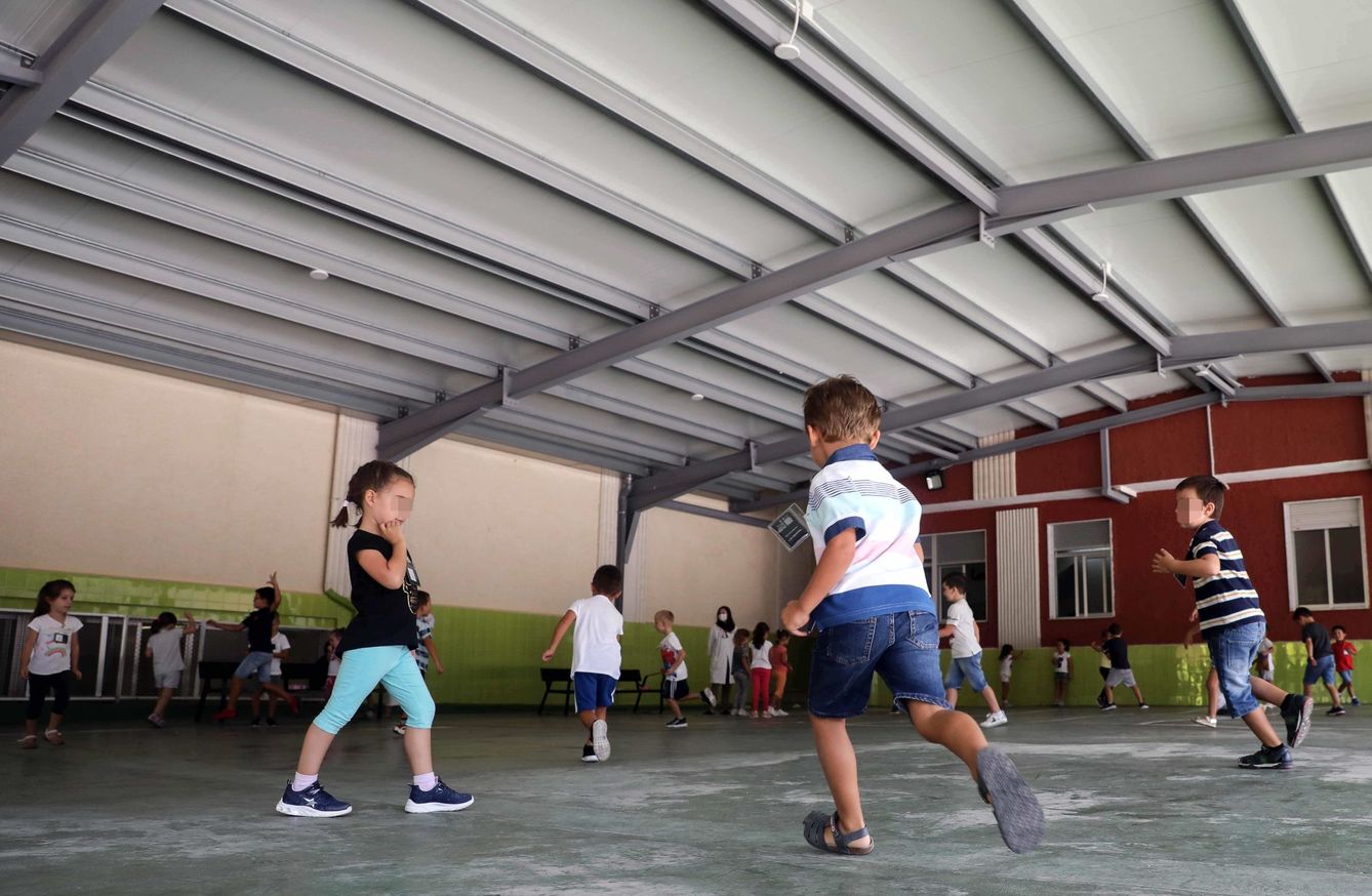 Un grupo de niños juega con distancia en un patio escolar. (EFE)