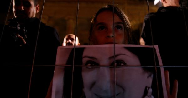 Foto: Una joven sostiene una foto de la periodista Daphne Caruana Galizia durante una vigilia en Valletta, Malta. (Reuters)