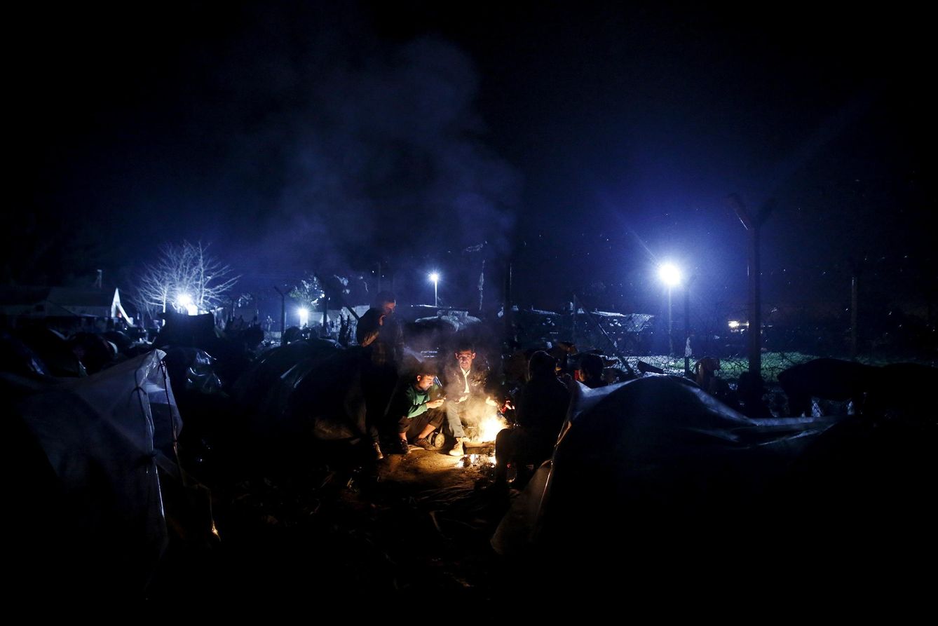 Un refugiado sirio y su familia en torno a una fogata cerca de la frontera entre Grecia y Macedonia, en Idomeni (Reuters).