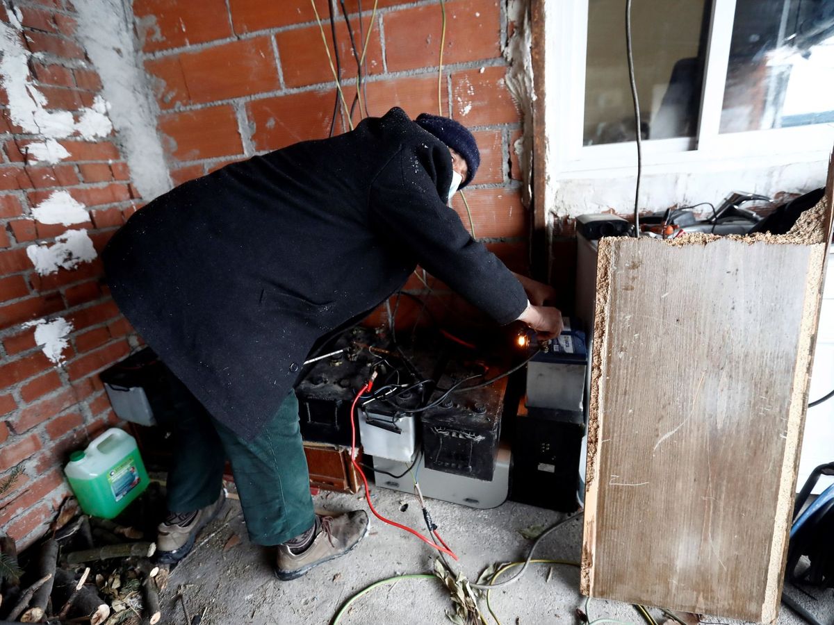 Foto: Un vecino manipula un generador para intentar calentar su casa en el asentamiento de la Cañada Real (Madrid). (EFE)