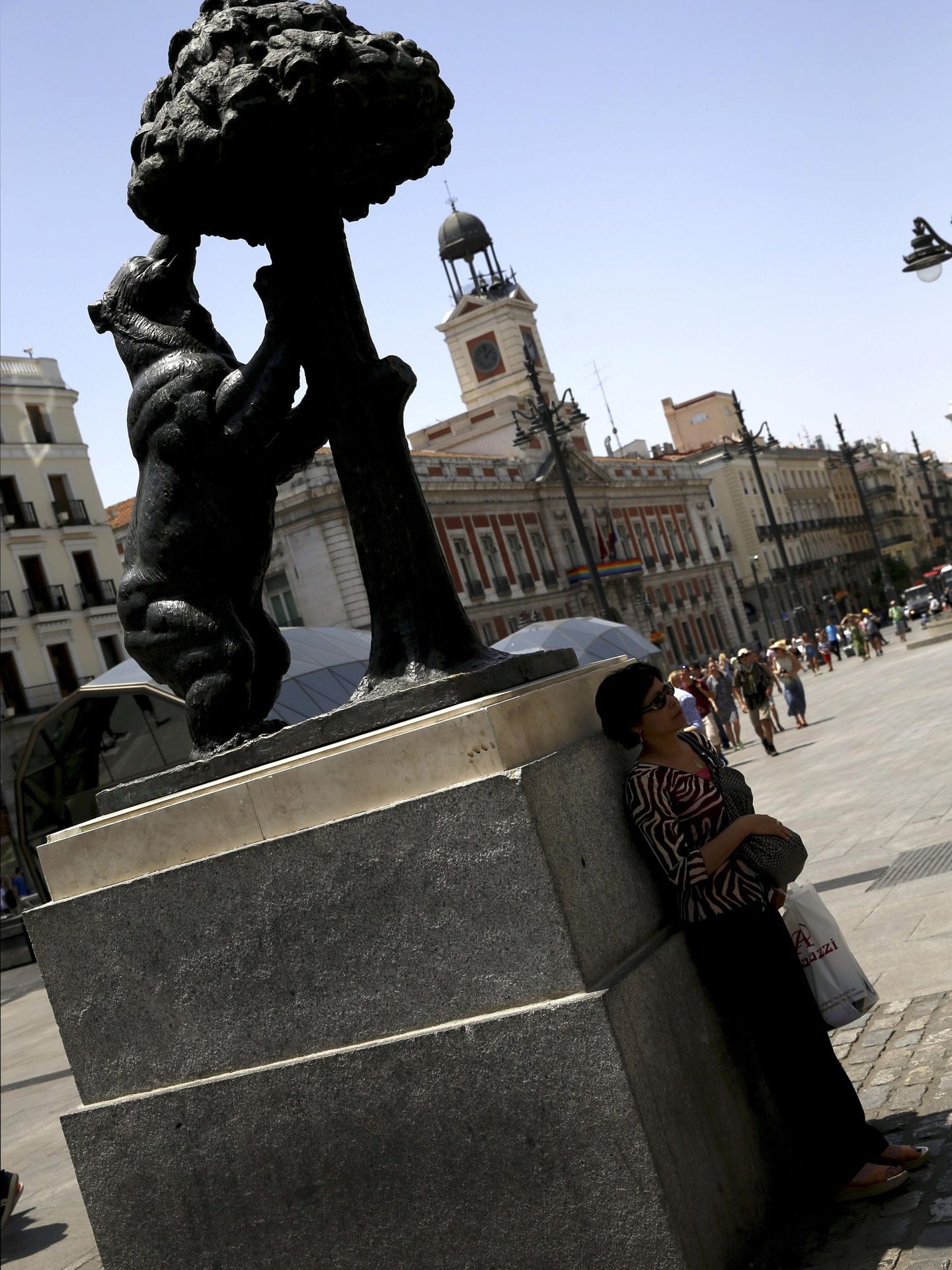 Una mujer junto a la sombra de la estatua del Oso y el Madroño en la Puerta del Sol de Madrid. (EFE/Sergio Barrenechea)