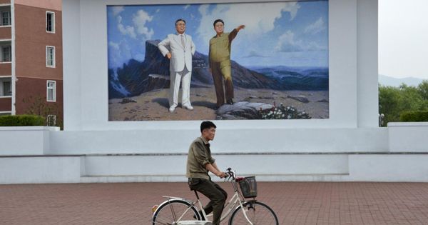 Foto: Un ciclista pasa junto a los retratos de Kim Il Sung y Kim Jong Il en el puerto de Rajin, Corea del Norte, en julio de 2014. (Reuters)