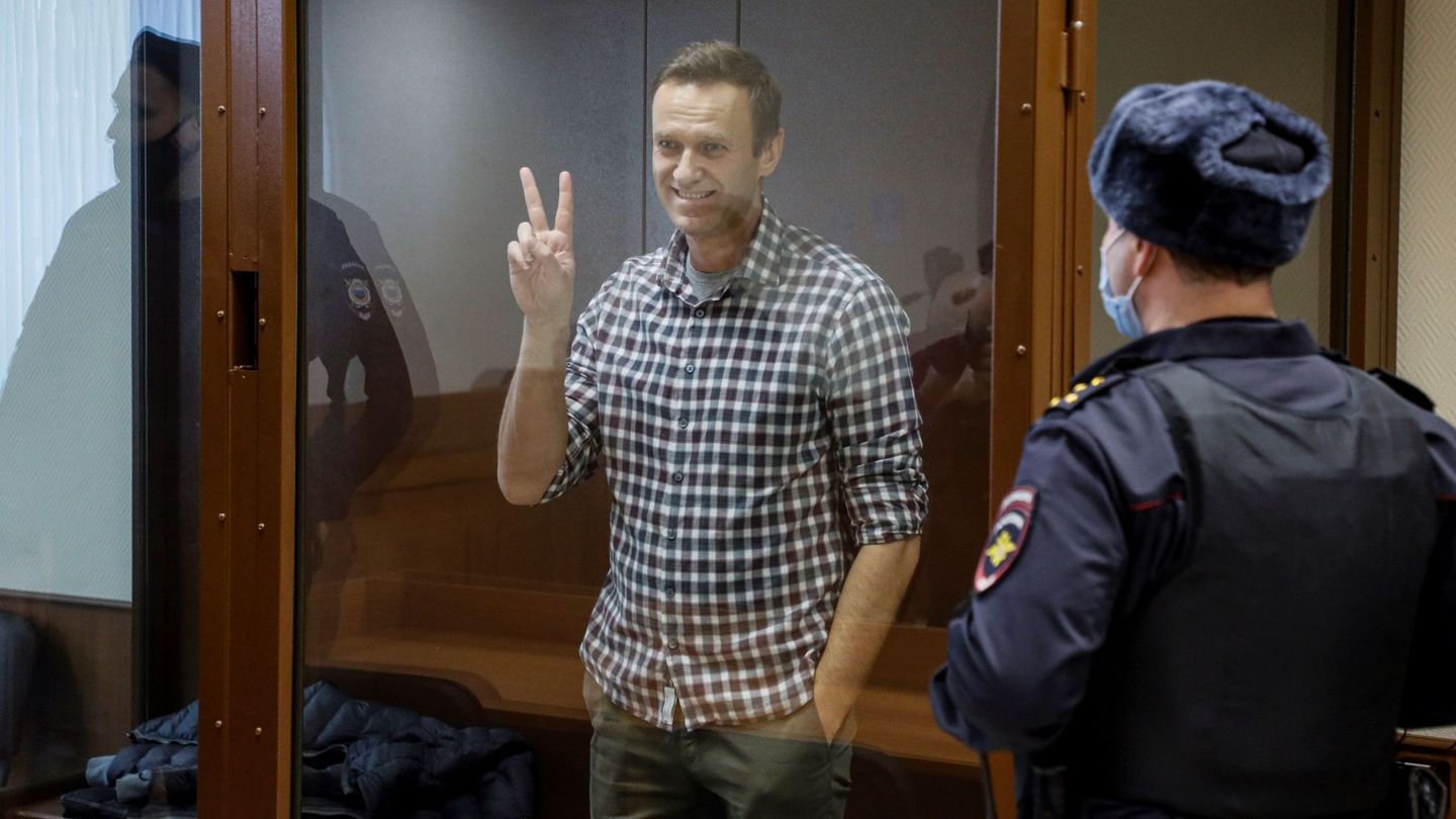 EA6213. MOSCÚ (RUSIA), 20 02 2021.- - El líder opositor ruso Alexéi Navalni hace el signo de la victoria desde una celda de cristal durante una nueva sesión de su batalla en los tribunales, que este sábado examina su apelación a la pena de 3,5 años de prisión a la que fue condenado y dictan sentencia en un juicio en su contra por presunta difamación de un veterano de la Segunda Guerra Mundial. EFE  Yuri Kochetkov