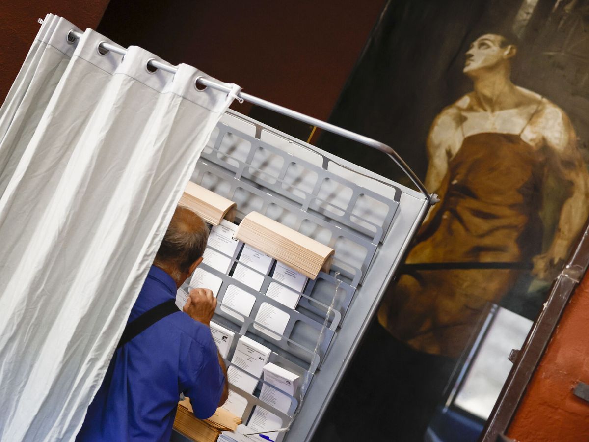Foto: Un votante elige su papeleta para las elecciones generales. (EFE/Sergio Pérez)