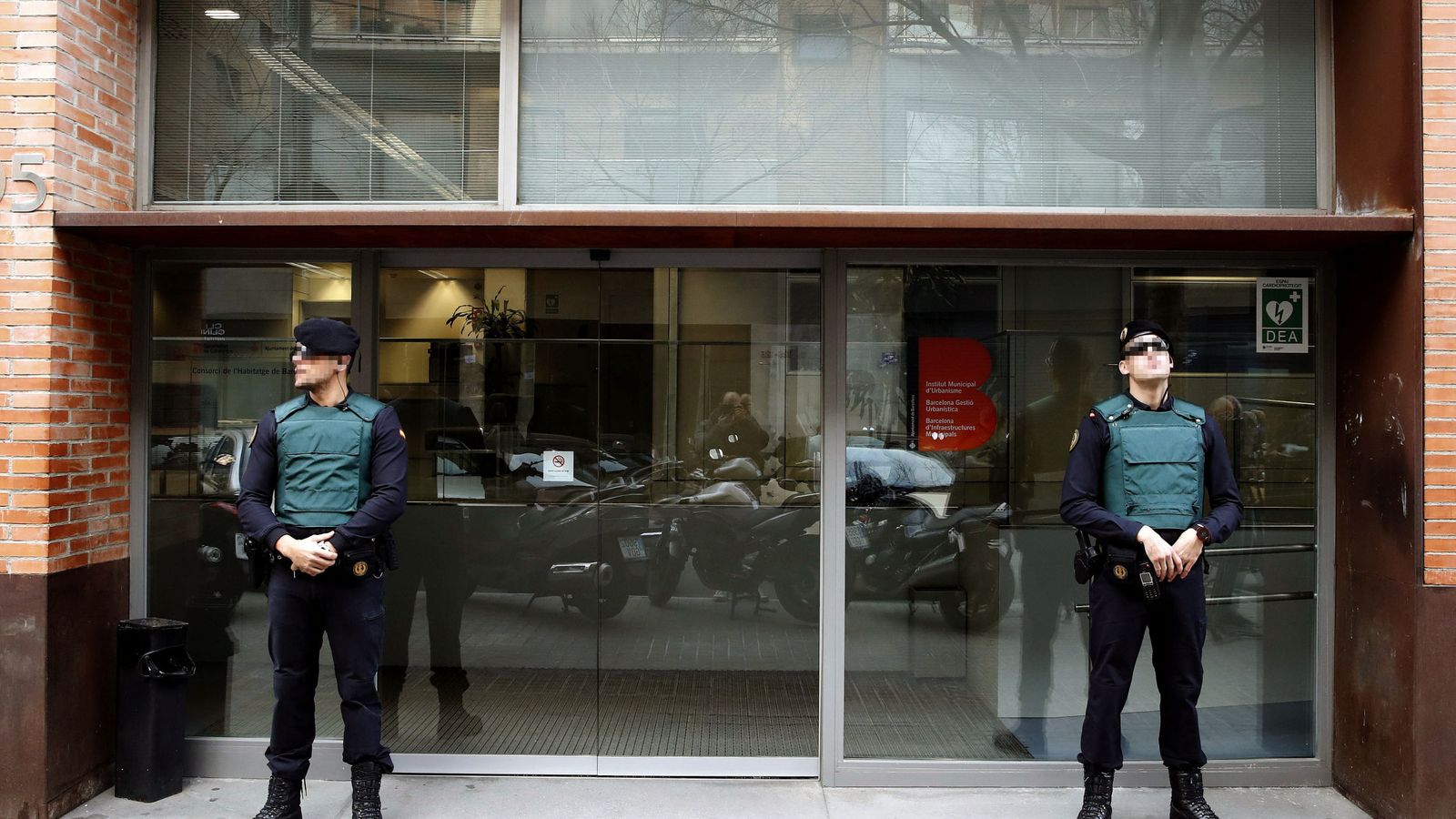 Foto: Dos agentes de la Guardia Civil custodian el acceso a la sede de Bimsa, en Barcelona, este jueves. (EFE)