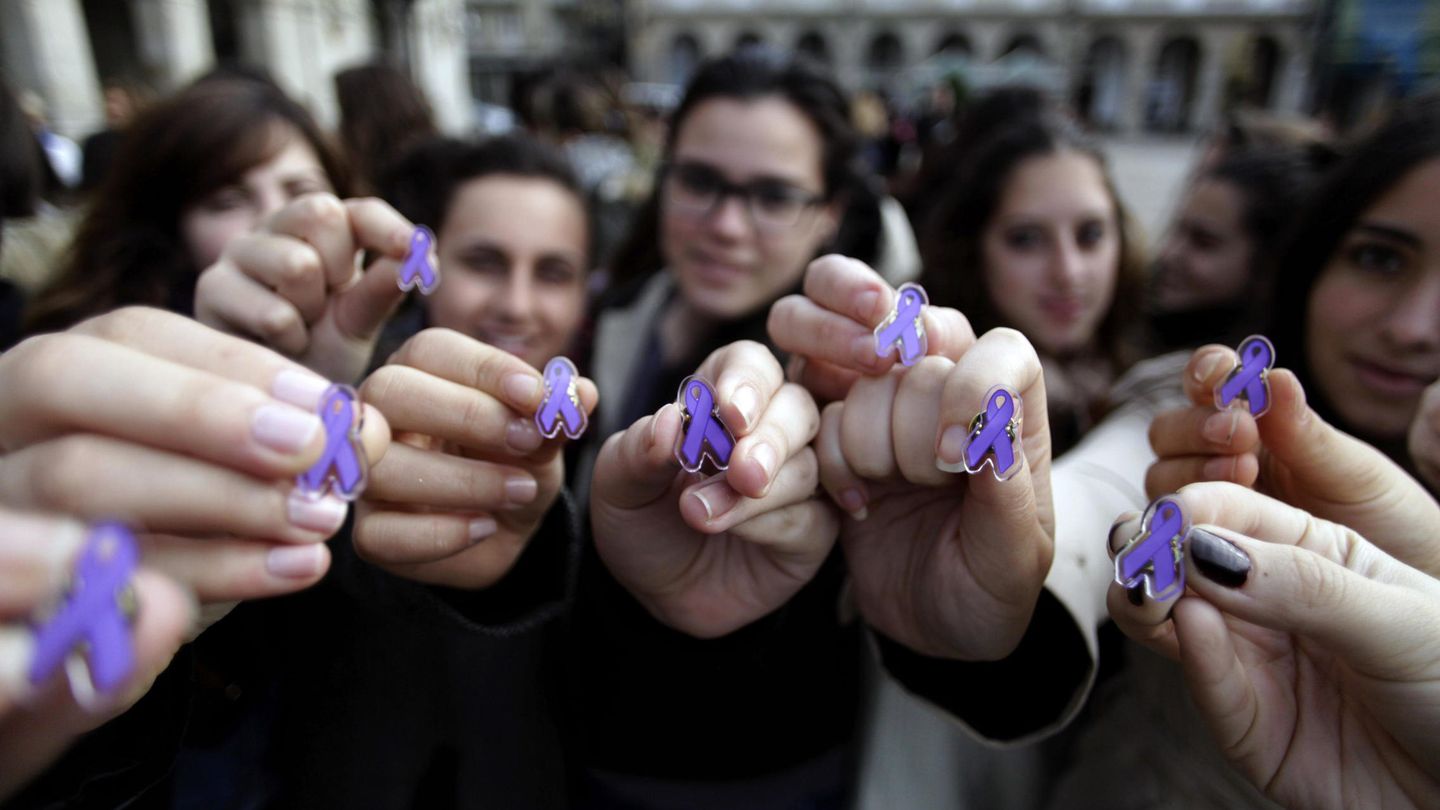 Varias jóvenes muestran lazos de color violeta, que simbolizan la lucha contra la violencia machista. (EFE)