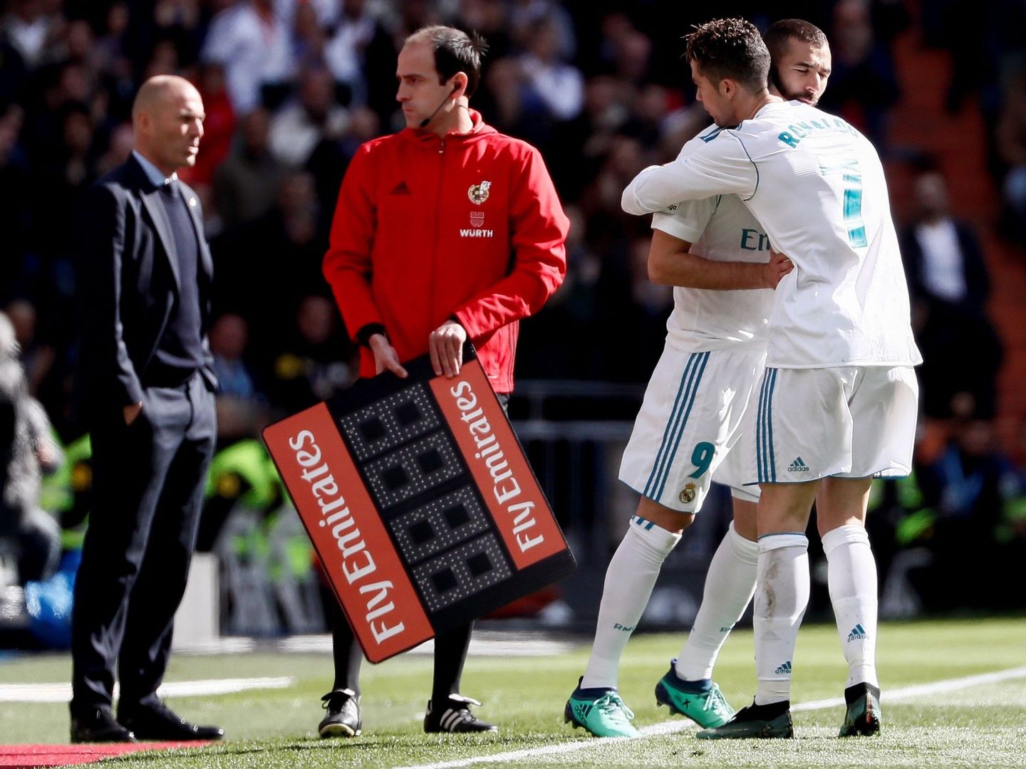 Cristiano y Benzema se abrazan en un cambio. (EFE) 