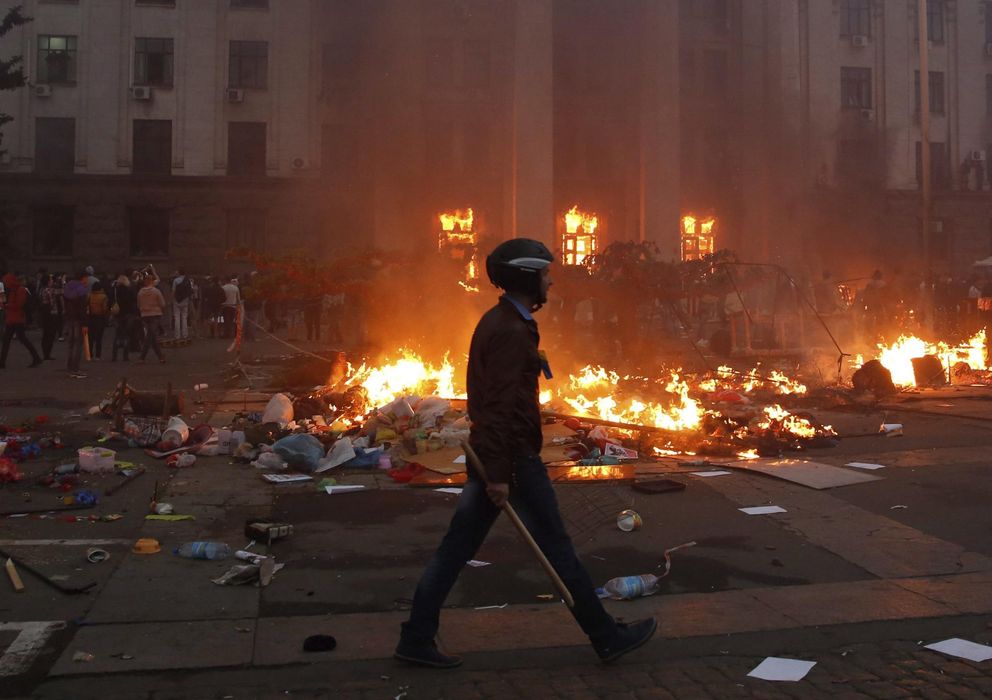 Foto: Un proucraniano camina ante la Casa de los Sindicatos de Odesa, incendiada el 2 de mayo cuando los prorrusos permanecían en su interior. Hubo al menos 42 muerto