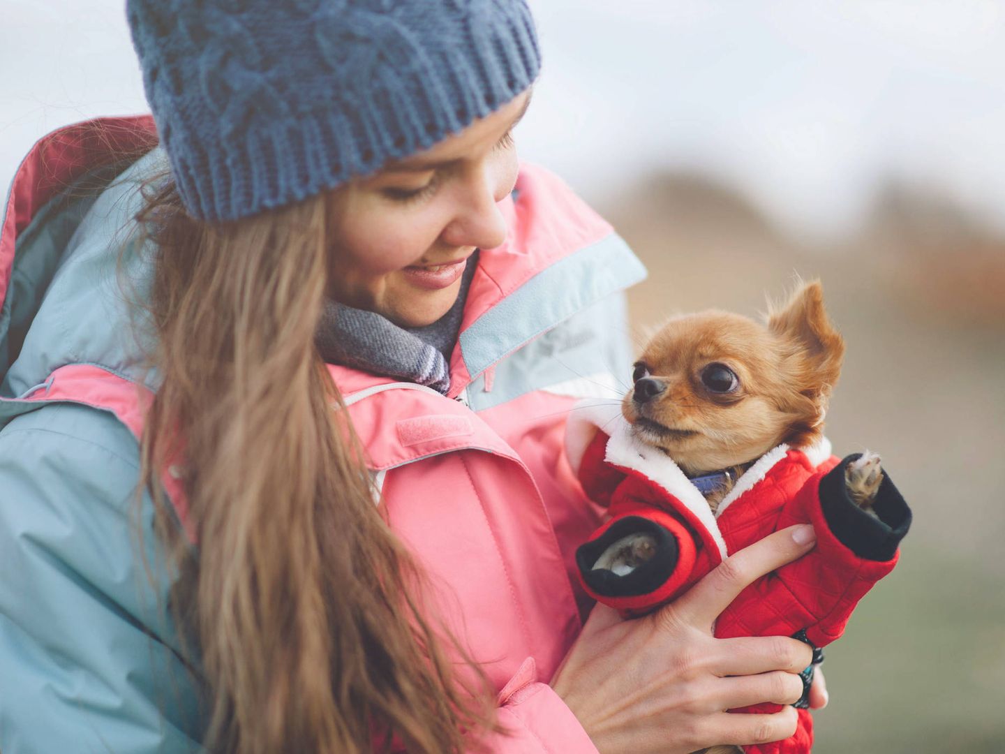 Una chica sale a pasear con su perro, casi tan abrigado como ella. (iStock)