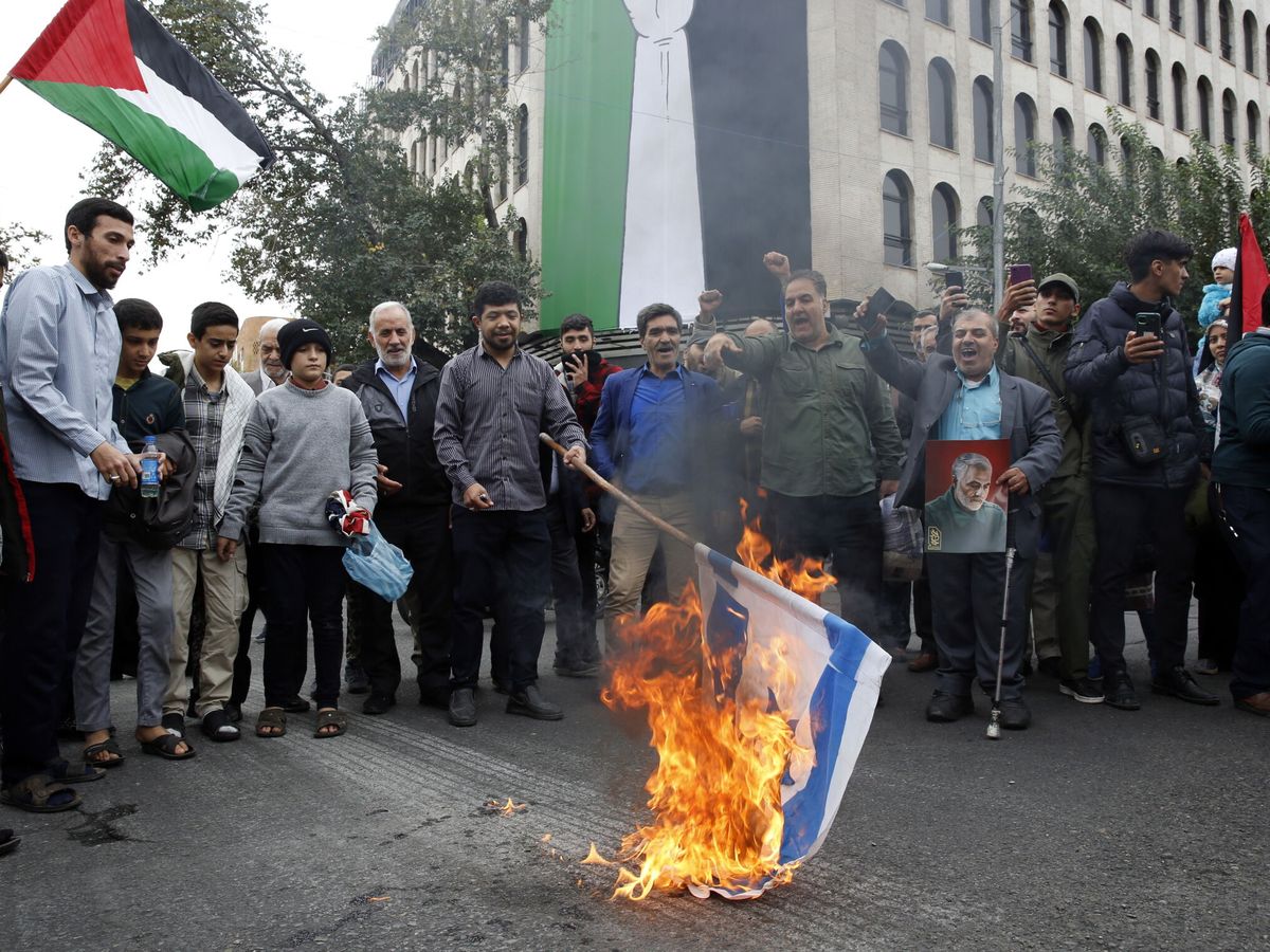 Foto: Un grupo de iraníes quema una bandera israelí durante una manifestación para mostrar solidaridad con el pueblo palestino. (EFE/Abedin Taherkenareh)